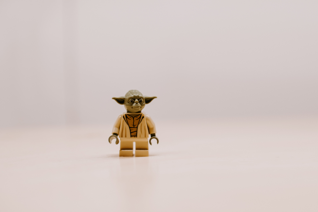 Lego Yoda standing on a white background.