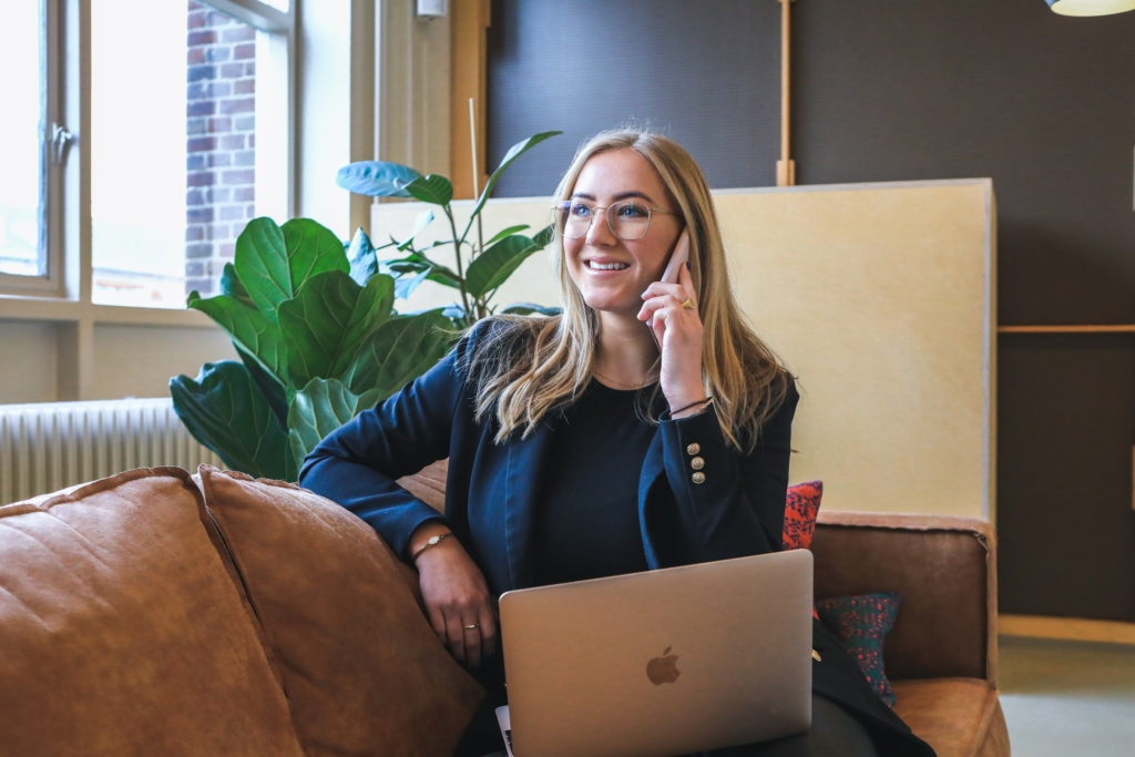 A woman with her computer and phone, possibly searching for the right hvac company.